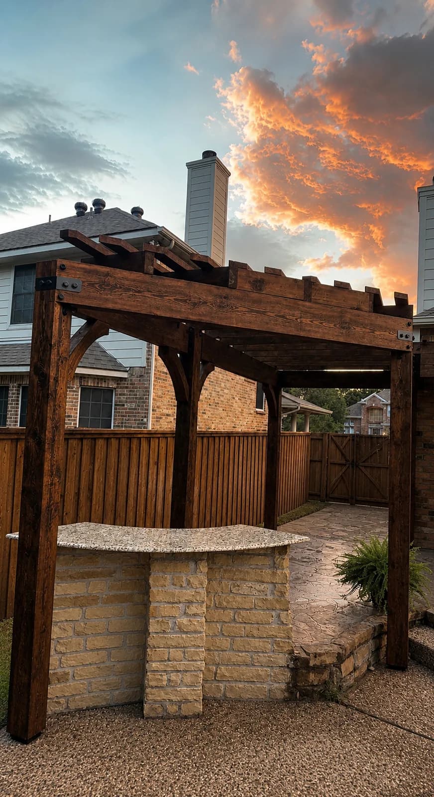 Cedar pergola over a stone outdoor bar at sunset.